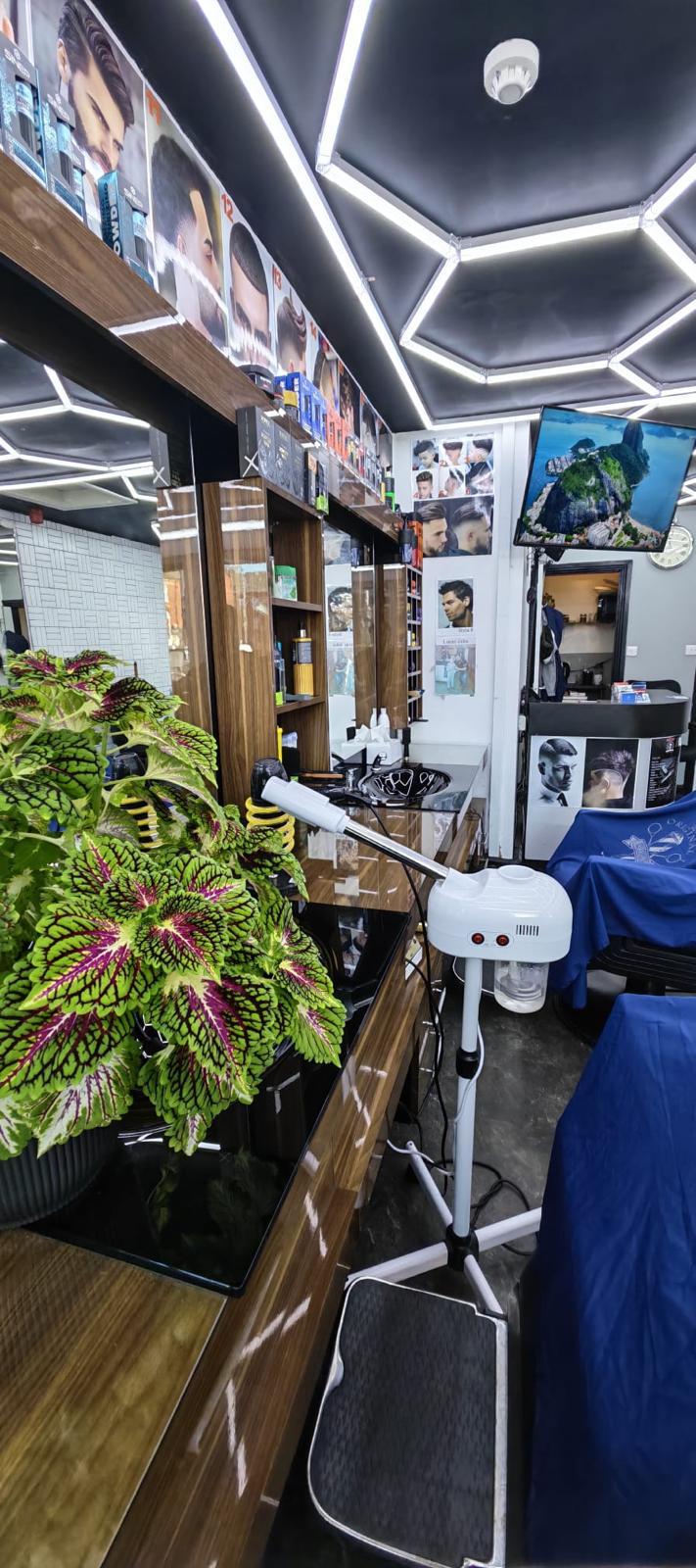 Inside Top Ten Barbers showing the grooming stations and bright geometric ceiling lights